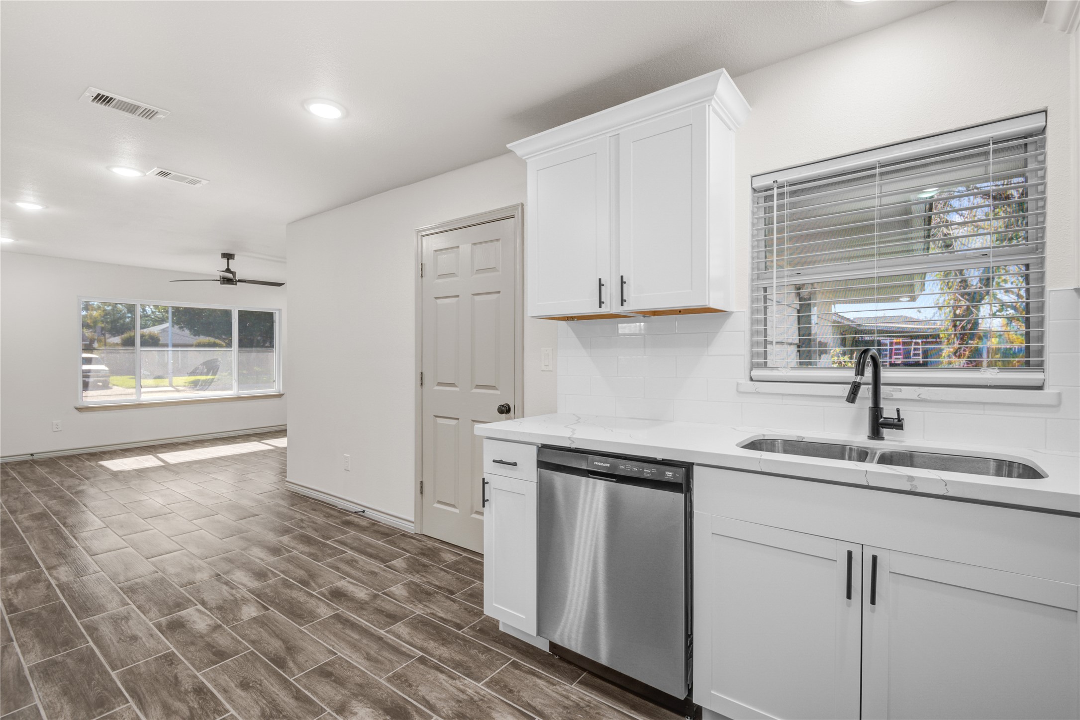 1530 West 10th Street Freeport, TX 77541 - Photo 11 of 32 a kitchen with stainless steel appliances granite countertop a sink and a white cabinets with wooden floor