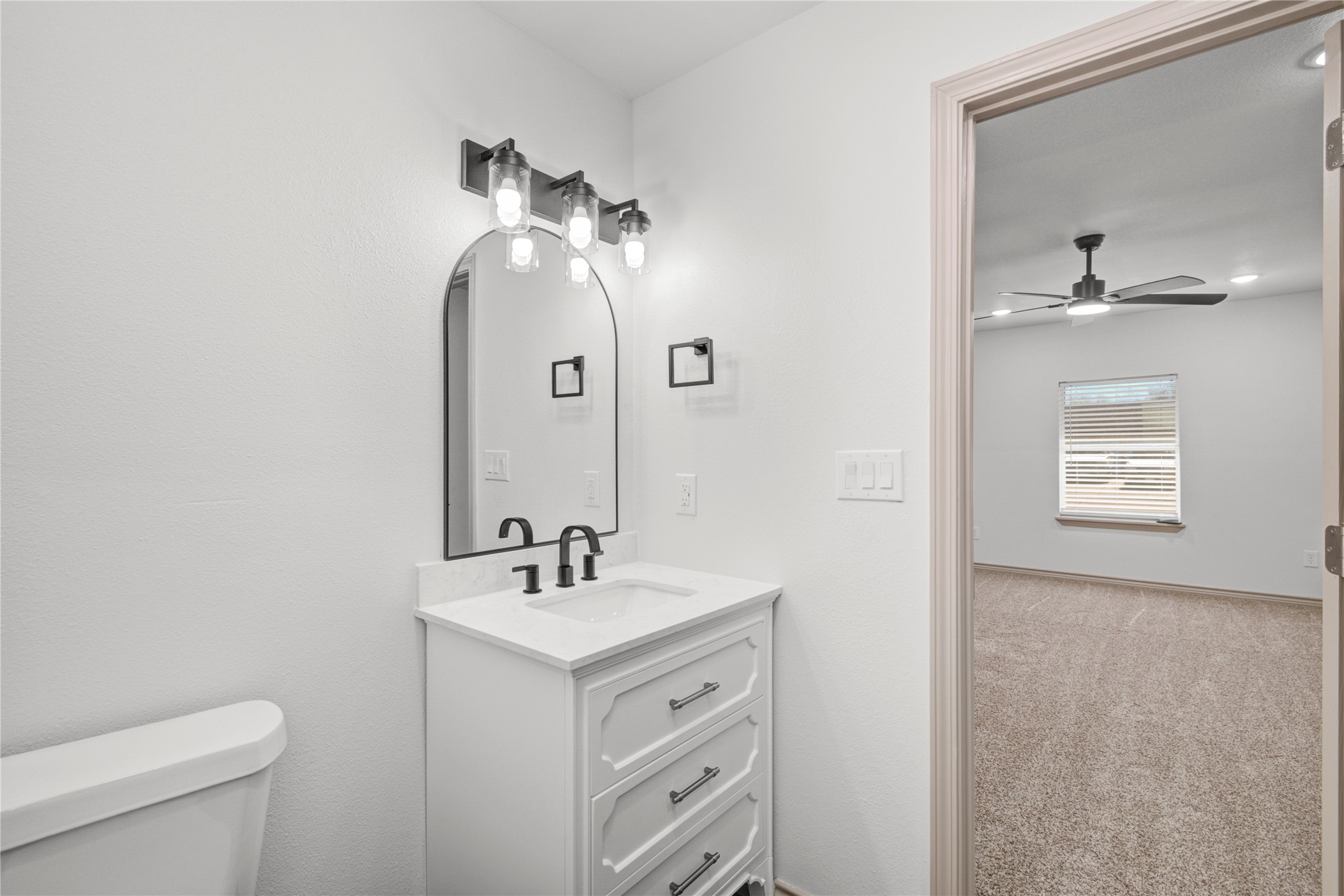 1530 West 10th Street Freeport, TX 77541 - Photo 26 of 32 a bathroom with a toilet sink and mirror