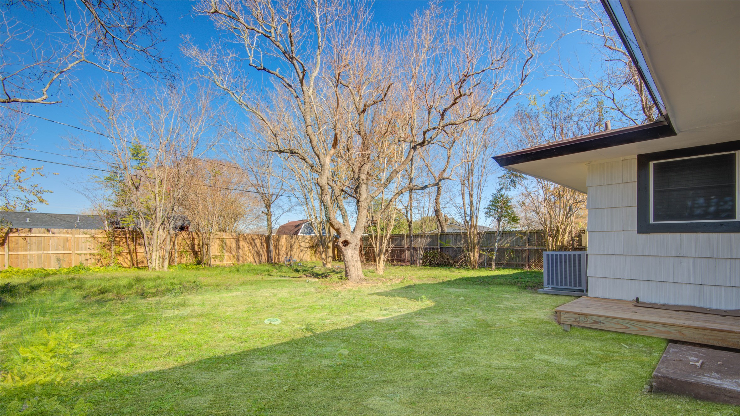 1530 West 10th Street Freeport, TX 77541 - Photo 29 of 32 a backyard of a house with large trees and outdoor seating