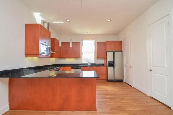 a kitchen with stainless steel appliances granite countertop a refrigerator and a sink