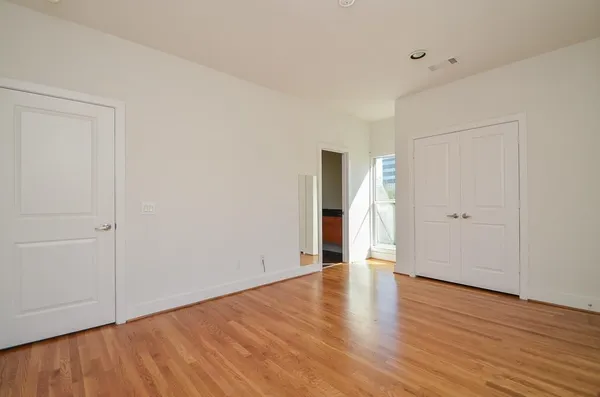a view of an empty room with wooden floor