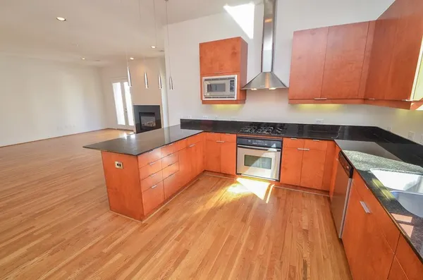 a kitchen with stainless steel appliances granite countertop a sink and wooden cabinets
