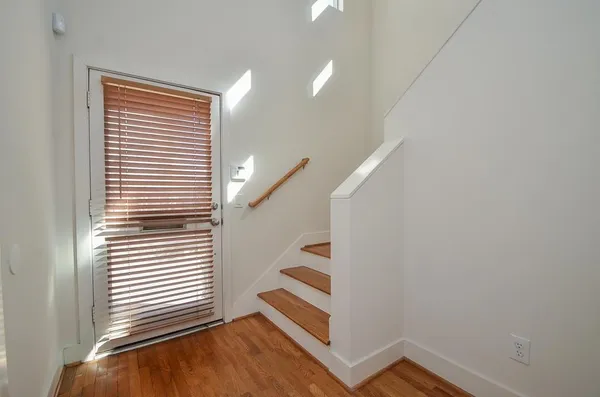 a view of a room with stairs and wooden floor