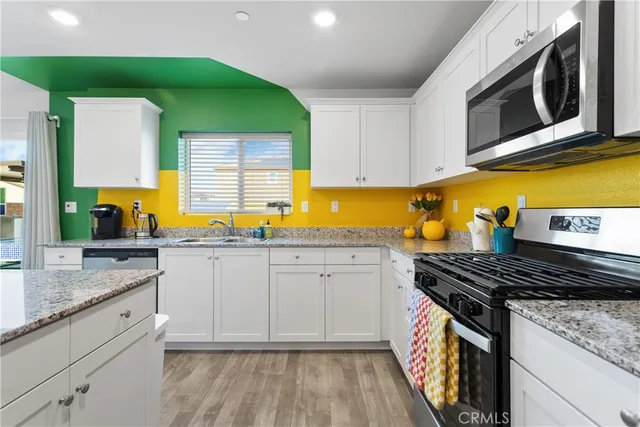 a kitchen with stainless steel appliances granite countertop a sink a stove a microwave and cabinets