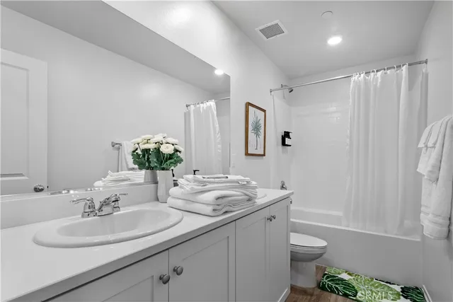 a bathroom with a double vanity sink toilet and shower