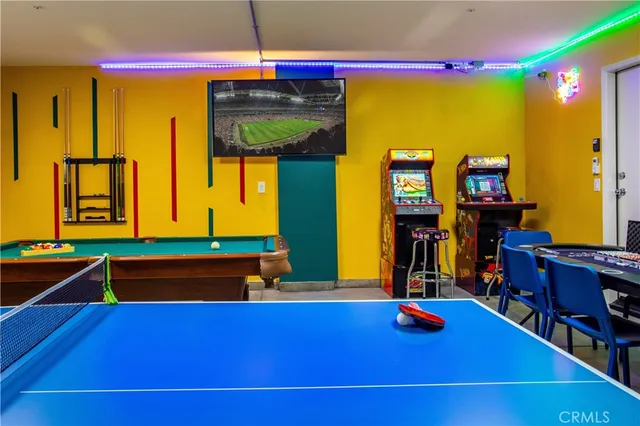 a room with wooden floor pool table and windows