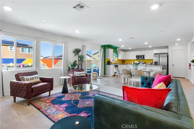 a living room with furniture kitchen view and a large window