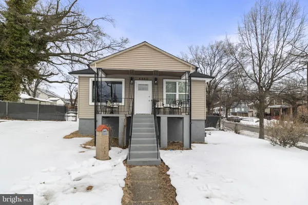 a front view of a house with a yard covered in snow