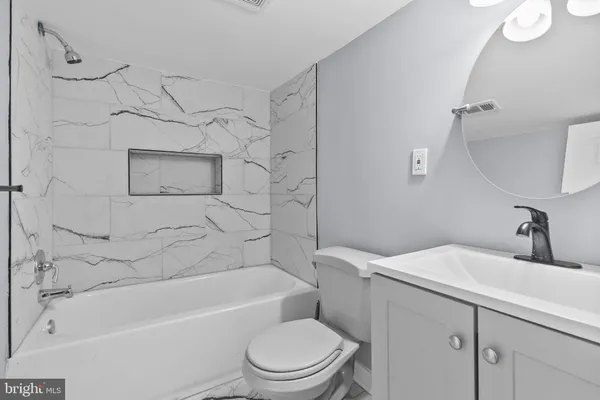 a bathroom with a toilet sink vanity tub and shower