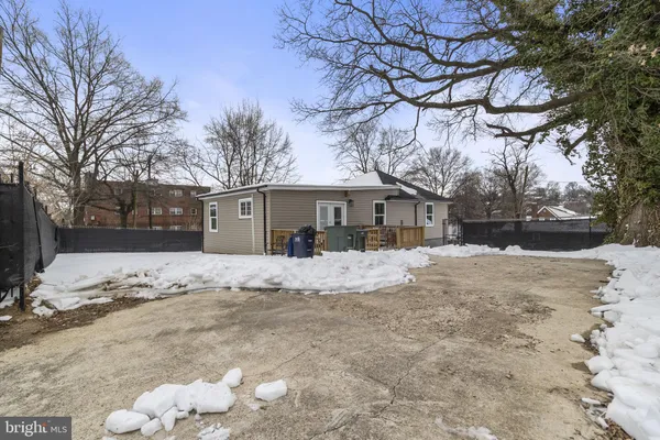 a front view of a house with a yard covered in snow