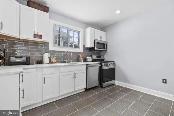 a kitchen with stainless steel appliances a sink a stove a microwave and cabinets