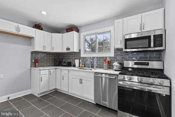 a kitchen with stainless steel appliances granite countertop a stove sink microwave and cabinets