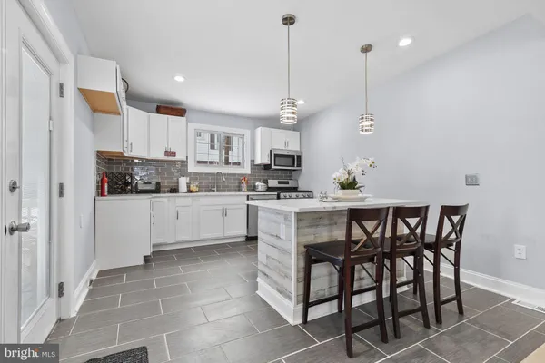 a kitchen with stainless steel appliances granite countertop a sink a stove a refrigerator and cabinets