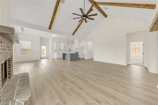 a view of empty room with wooden floor and a ceiling fan