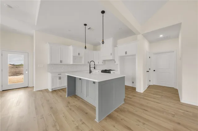 a kitchen with stainless steel appliances sink cabinets and wooden floor