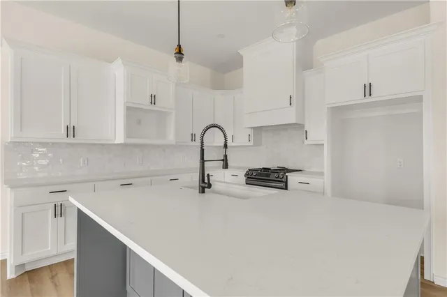 a kitchen with white cabinets and a stove