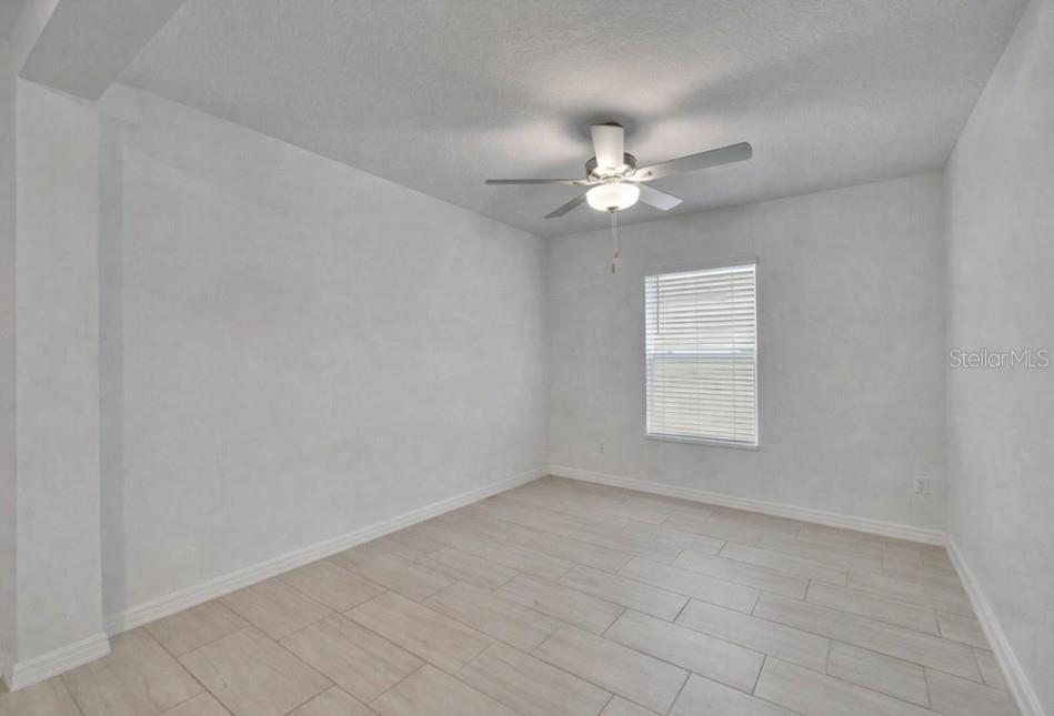 34780 Rainville Loop Zephyrhills, FL 33541 - Photo 11 of 30 an empty room with a window and a ceiling fan
