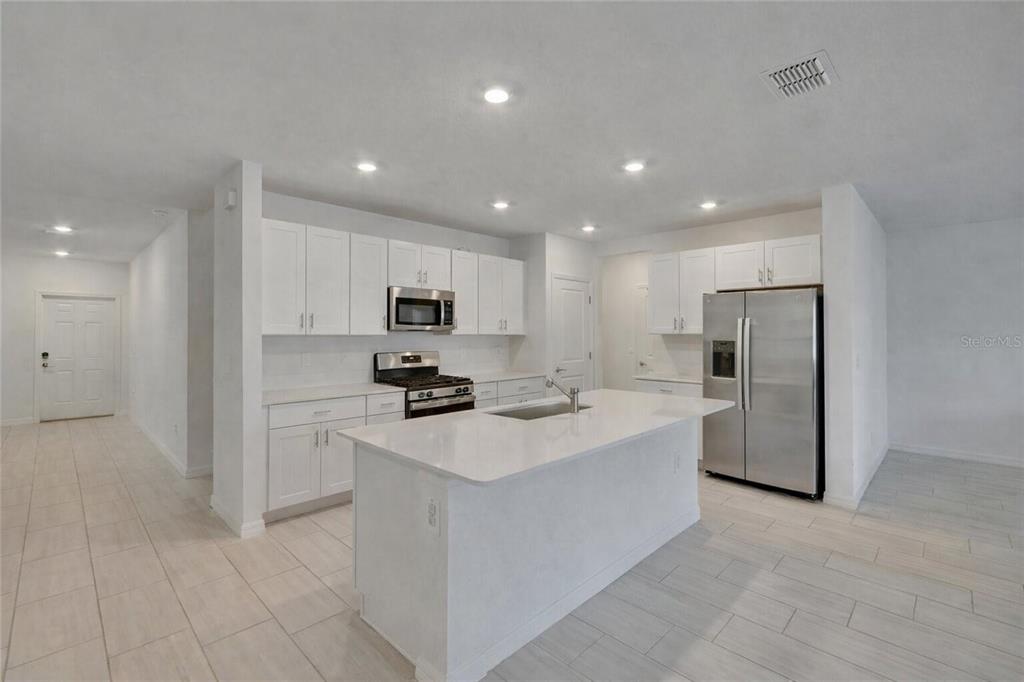 34780 Rainville Loop Zephyrhills, FL 33541 - Photo 13 of 30 a kitchen with stainless steel appliances a refrigerator stove microwave and sink