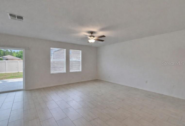 34780 Rainville Loop Zephyrhills, FL 33541 - Photo 14 of 30 an empty room with windows and chandelier fan