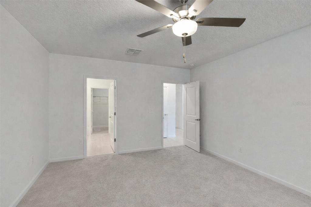 34780 Rainville Loop Zephyrhills, FL 33541 - Photo 15 of 30 an empty room with closet and a chandelier fan