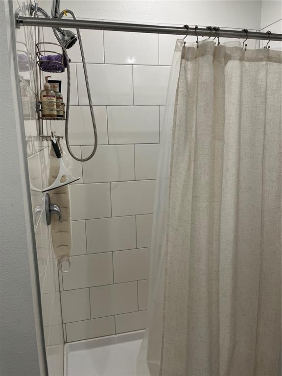 34780 Rainville Loop Zephyrhills, FL 33541 - Photo 16 of 30 a bathroom with a shower and a shower curtain