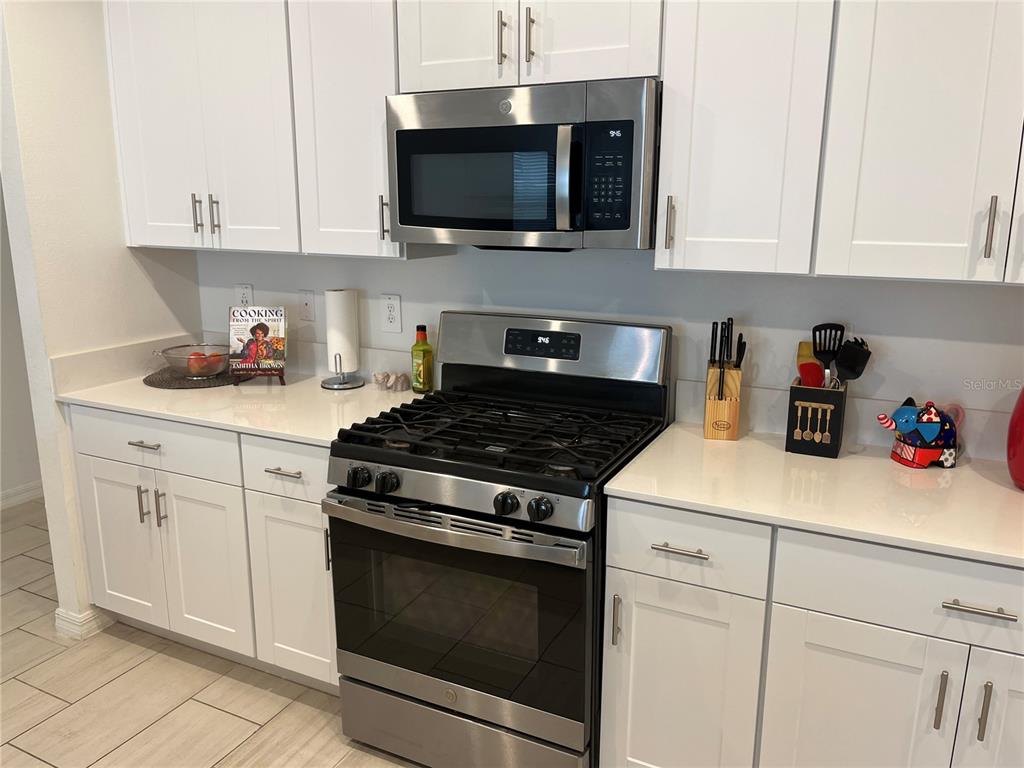 34780 Rainville Loop Zephyrhills, FL 33541 - Photo 18 of 30 a kitchen with white cabinets and appliances