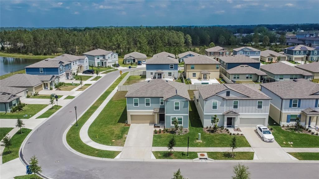 34780 Rainville Loop Zephyrhills, FL 33541 - Photo 3 of 30 an aerial view of a house with a garden and lake view
