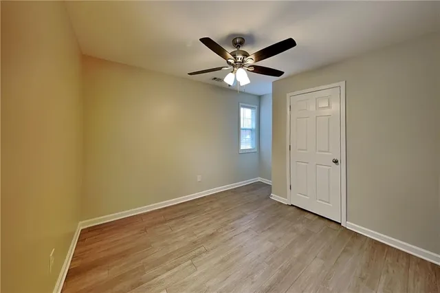 a view of a room with wooden floor and a ceiling fan