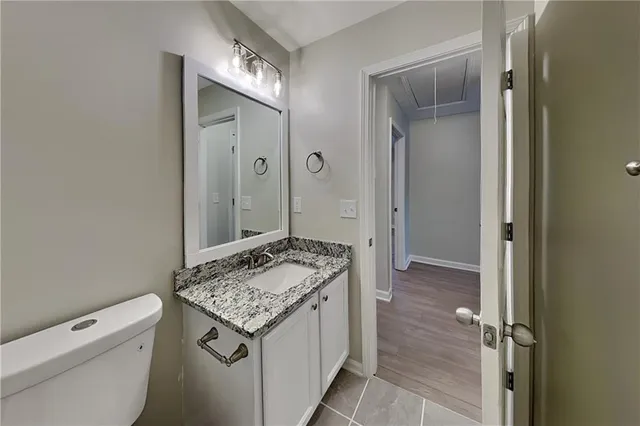 a bathroom with a granite countertop sink a toilet and shower
