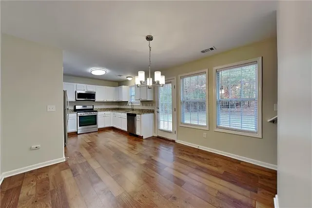 a view of a kitchen with granite countertop stainless steel appliances and wooden floor