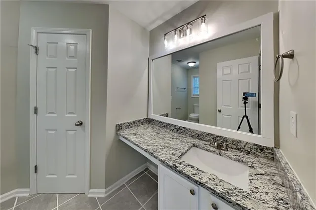 a bathroom with a granite countertop sink and a mirror