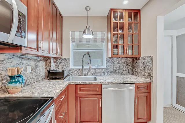 a kitchen with stainless steel appliances granite countertop a sink stove and microwave