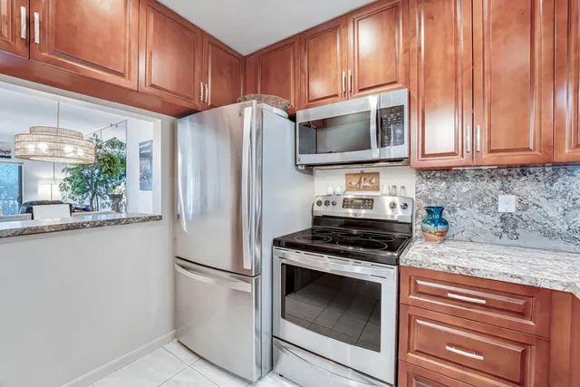 a kitchen with stainless steel appliances granite countertop a stove and a refrigerator