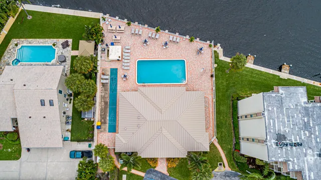 an aerial view of a house with a garden and lake view