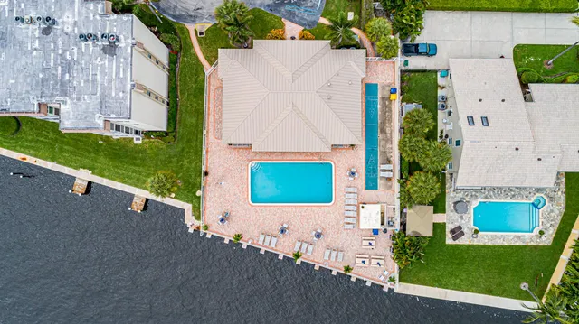 a view of a house with a yard and palm trees