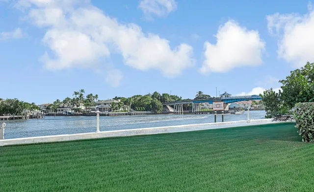 a view of a lake with a big yard and large trees