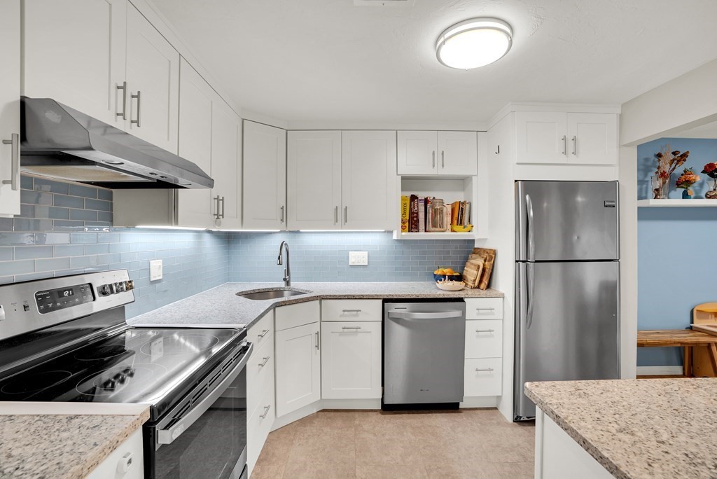 214 Ridgefield Circle, Unit B Clinton, MA 01510 - Photo 16 of 32 a kitchen with stainless steel appliances granite countertop a sink stove and refrigerator