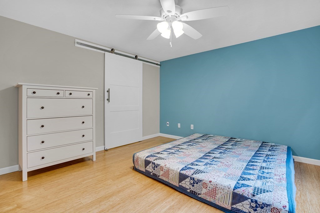 214 Ridgefield Circle, Unit B Clinton, MA 01510 - Photo 28 of 32 a bedroom with a bed and a chandelier