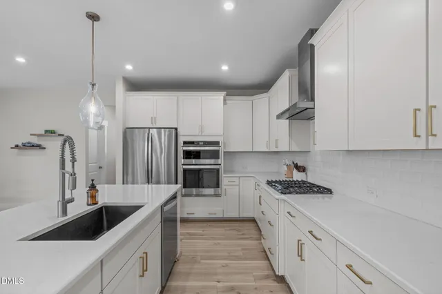 a kitchen with stainless steel appliances kitchen island granite countertop a sink and refrigerator