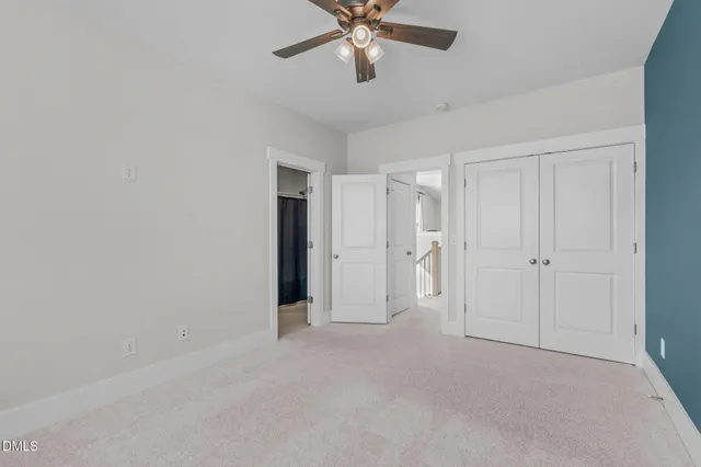 an empty room with a window and a ceiling fan