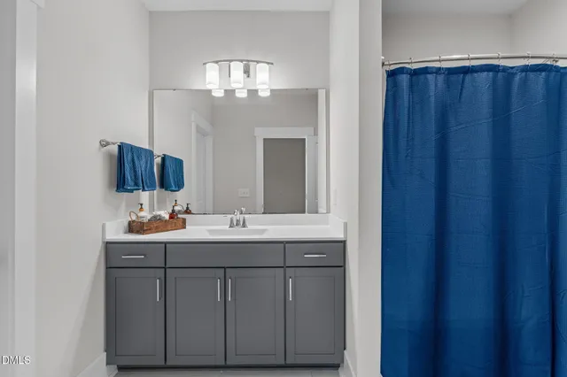 a view of an empty room and chandelier fan