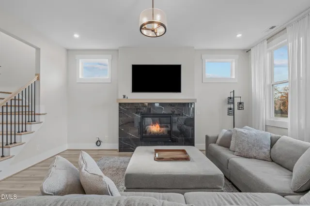 a living room with furniture a fireplace and a flat screen tv