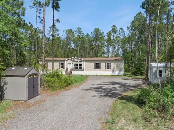a front view of a house with a yard and trees
