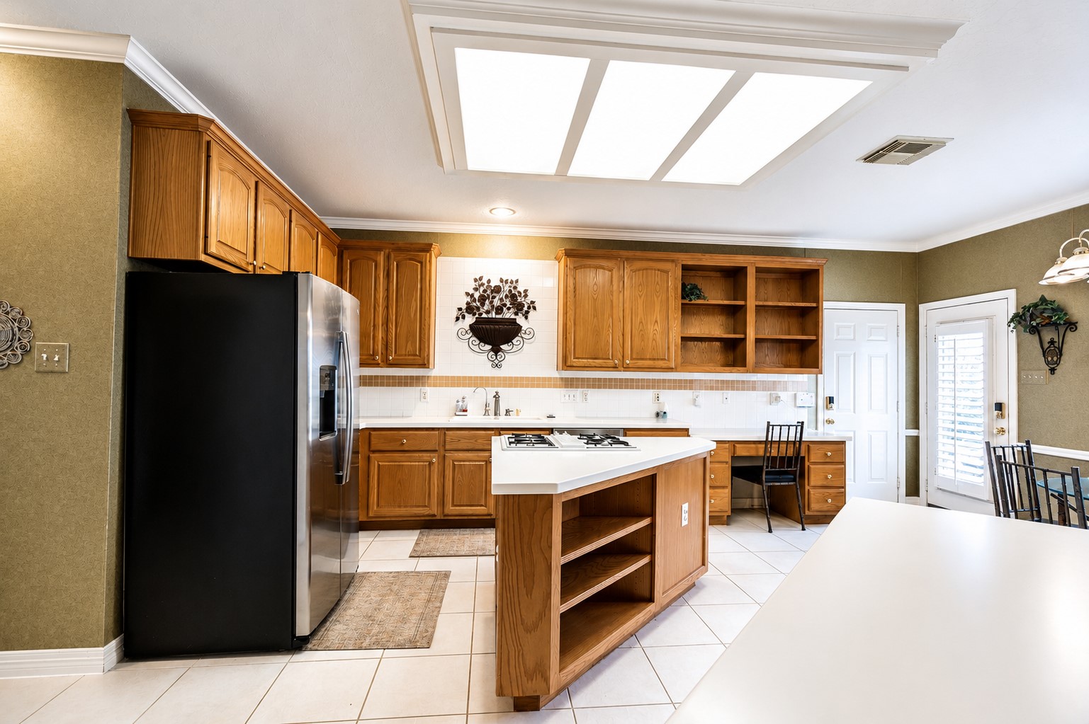 5718 Oakmoss Trail Spring, TX 77379 - Photo 14 of 47 Bright island kitchen with abundant storage and stainless-steel appliances, including a dishwasher and 2023 refrigerator staying with the house.