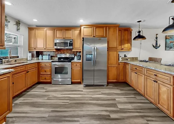 a kitchen with stainless steel appliances a stove top oven and a refrigerator