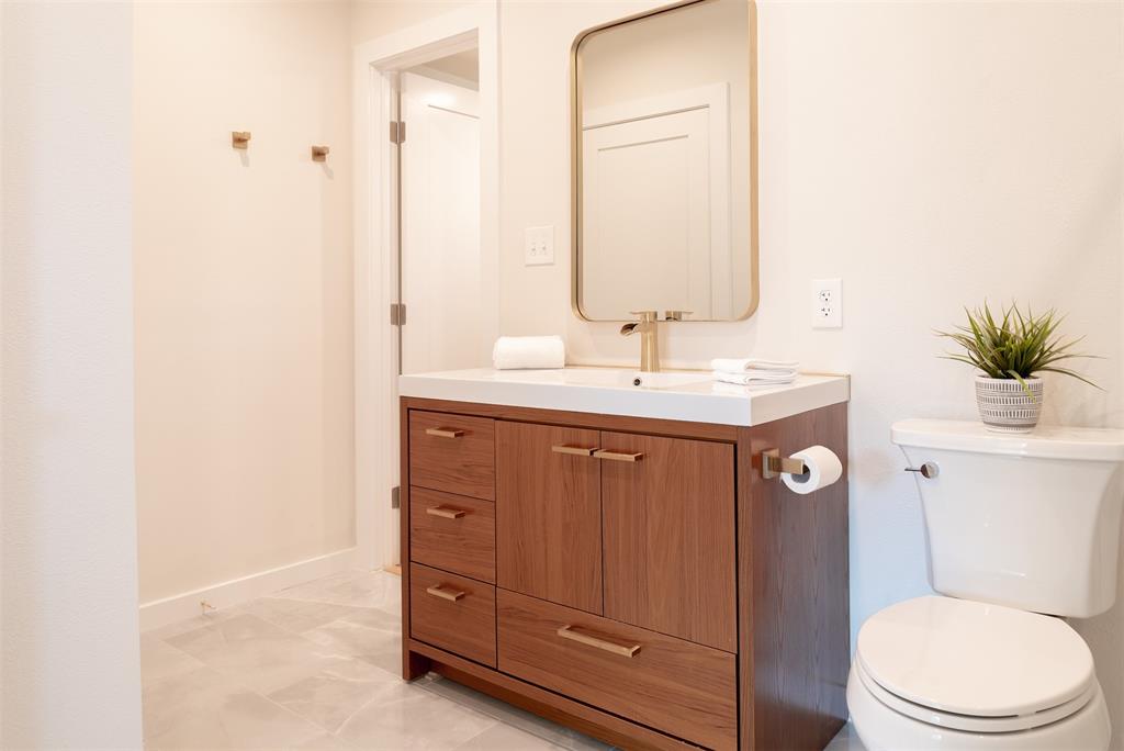 210 Davis Road Granbury, TX 76049 - Photo 14 of 28 a bathroom with a toilet a sink and mirror