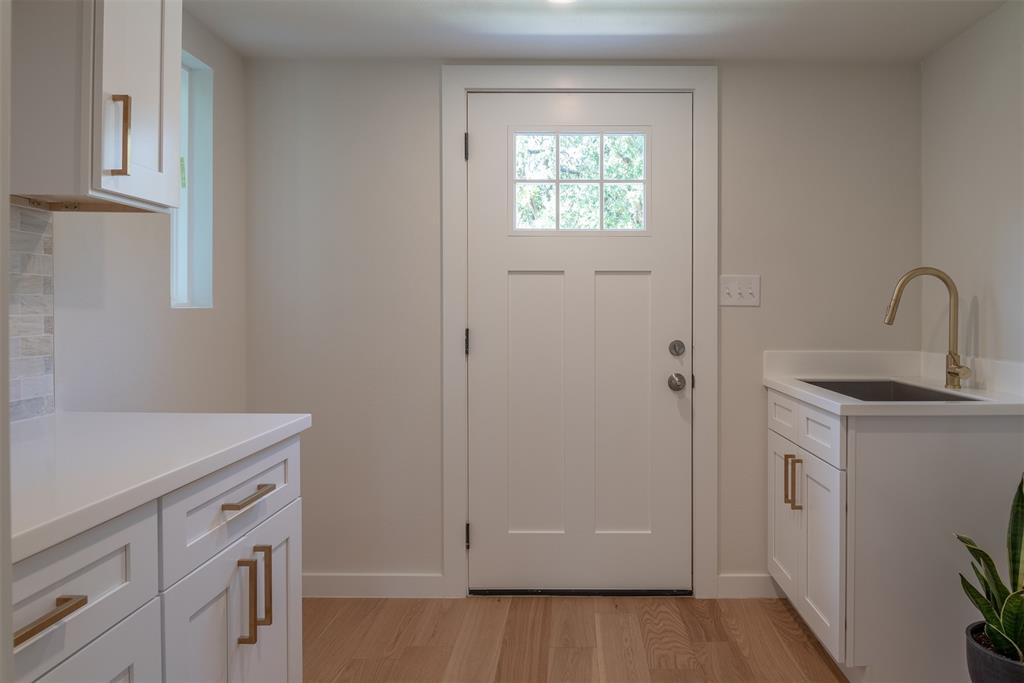 210 Davis Road Granbury, TX 76049 - Photo 16 of 28 a view of a kitchen with sink dishwasher and wooden floor