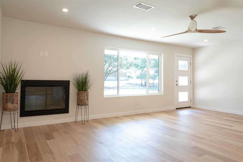 210 Davis Road Granbury, TX 76049 - Photo 21 of 28 an empty room with wooden floor cabinet and windows