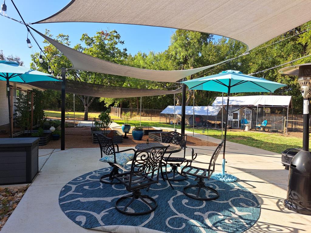 210 Davis Road Granbury, TX 76049 - Photo 25 of 28 a view of a patio with a table and chairs under an umbrella