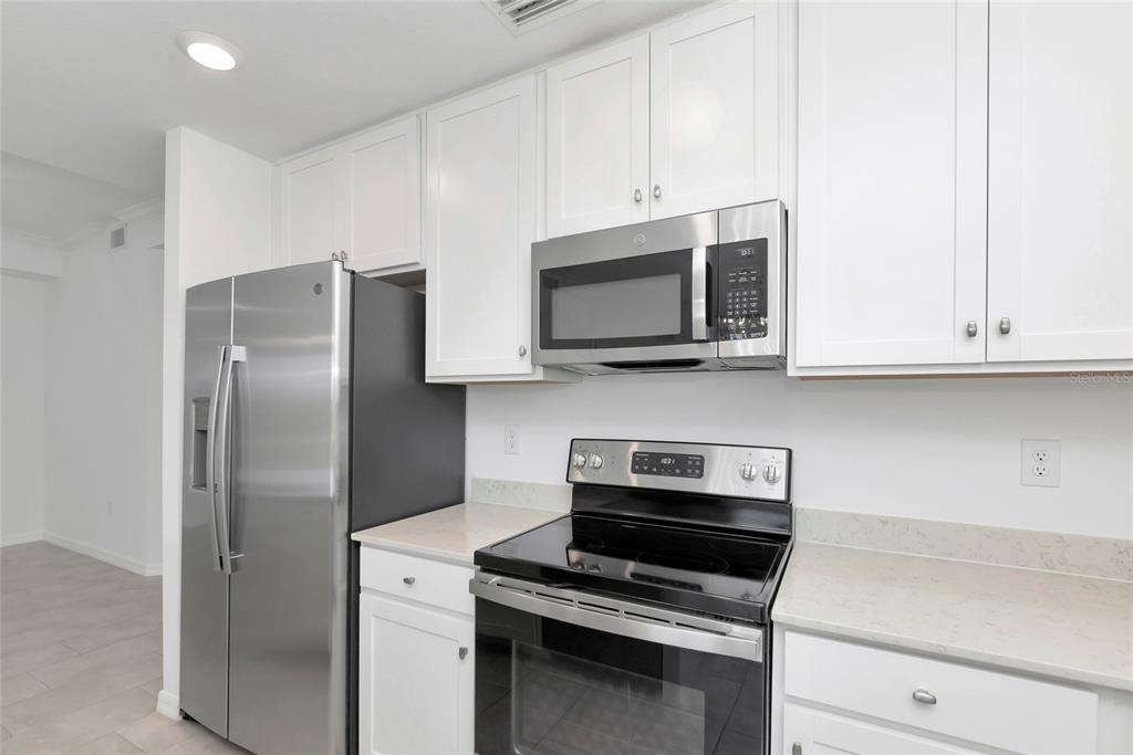 18008 Gawthrop Drive, Unit 101 Lakewood Ranch, FL 34211 - Photo 13 of 56 a kitchen with stainless steel appliances white cabinets and a stove top oven